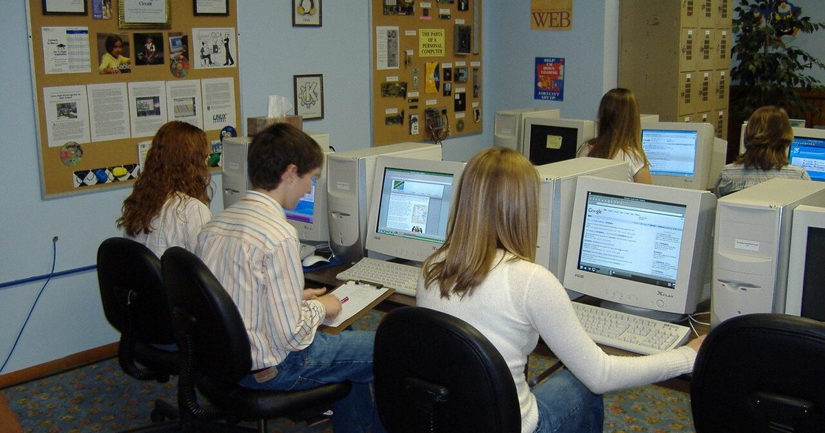 Estudantes trabalhando em uma atividade em conjunto no laboratório de informática