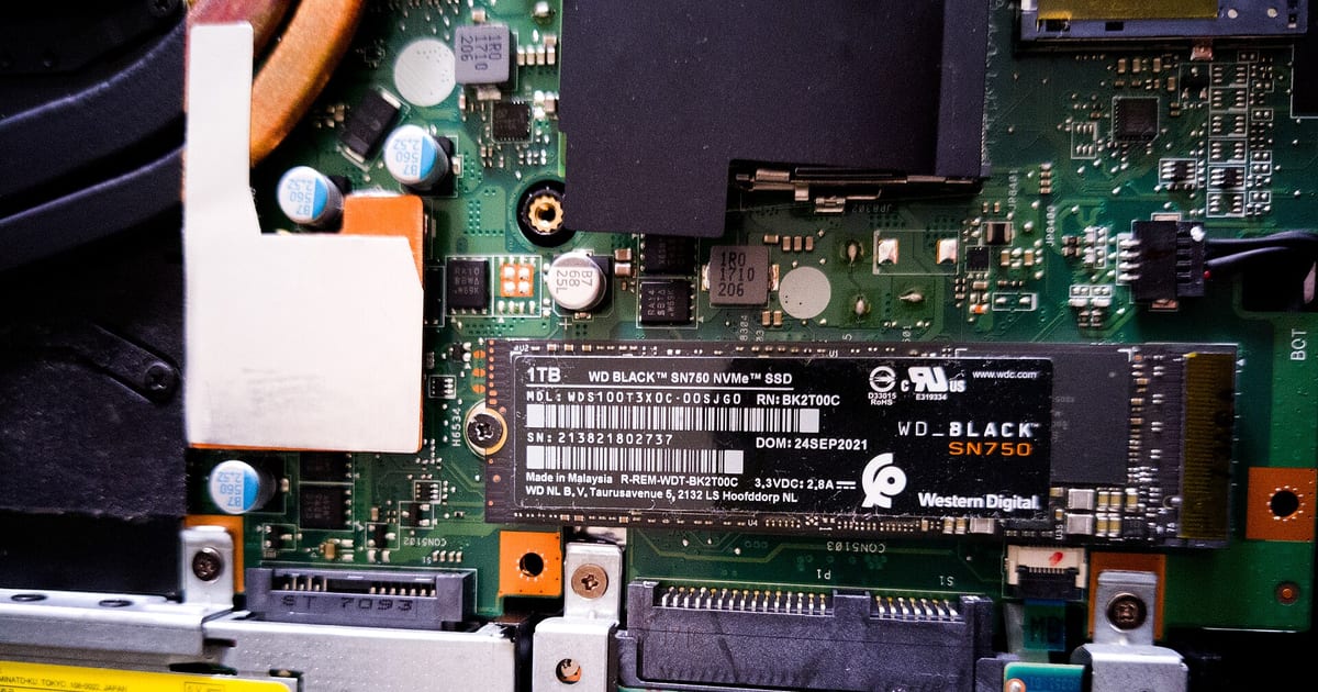 Unidade SSD no formato M.2 NVMe segurada pelas bordas antes da instalação