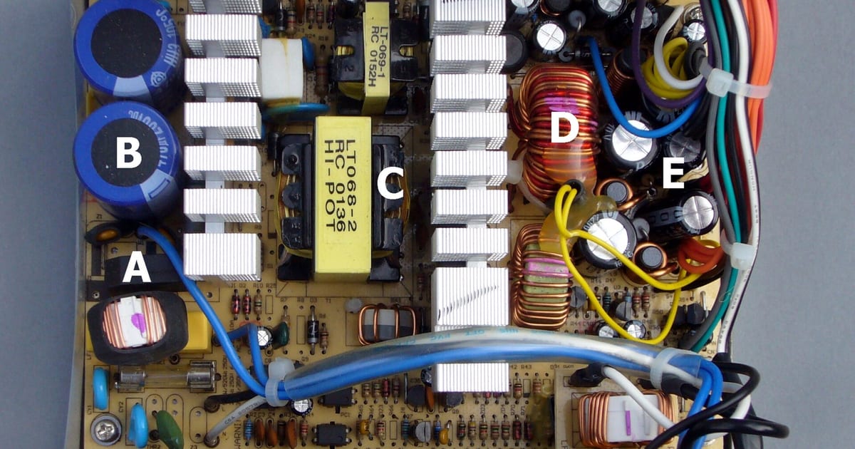 Interior de uma fonte de alimentação ATX de computador com capacitores e dissipadores