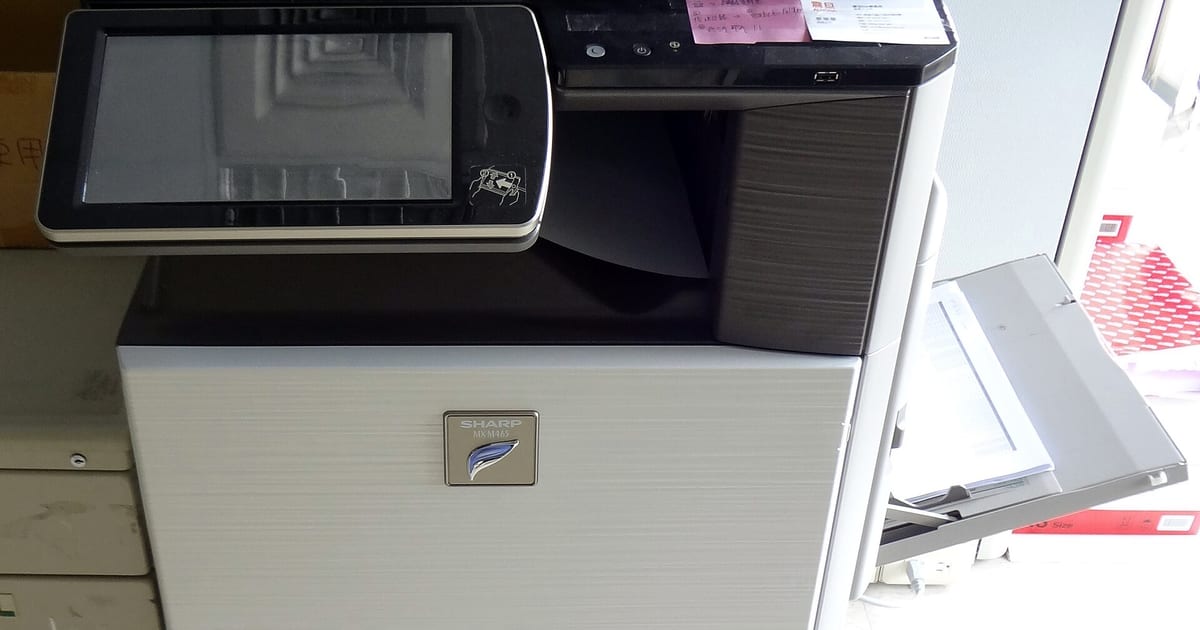 Multifuncional de escritório em uso, com bandeja de papel e painel frontal