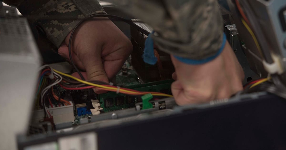 Técnico substituindo componentes internos de um computador sobre bancada de trabalho